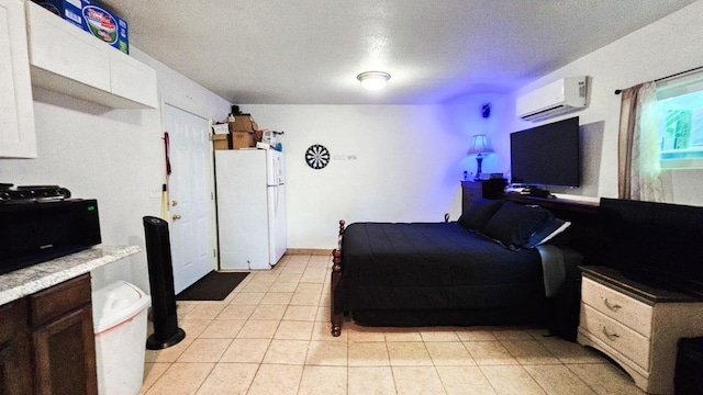 bedroom featuring freestanding refrigerator, a textured ceiling, a wall unit AC, and light tile patterned flooring