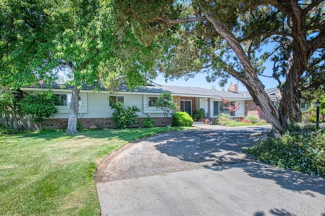 single story home featuring crawl space, a front yard, a chimney, and driveway