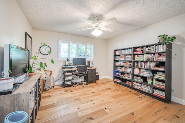 office with a textured ceiling, wood finished floors, baseboards, and ceiling fan