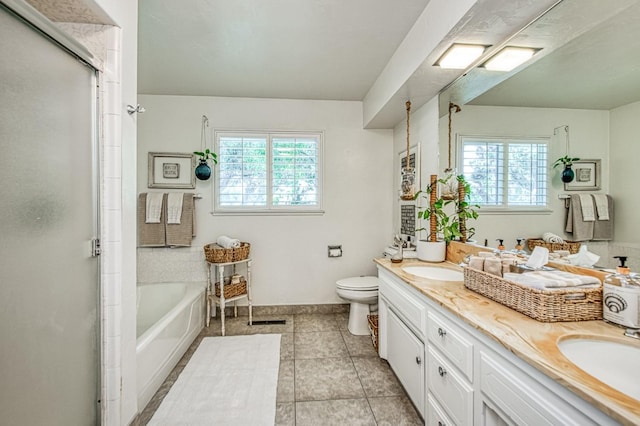 full bathroom featuring double vanity, toilet, a healthy amount of sunlight, and a sink