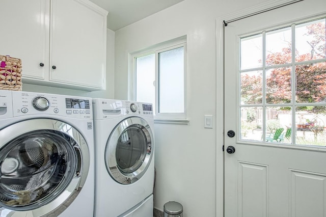 washroom featuring washing machine and dryer and cabinet space
