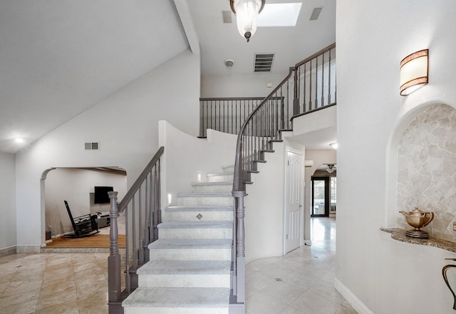 8164 N 8th St, Fresno, CA 93720 - stairway featuring high vaulted ceiling, tile patterned floors, arched walkways, baseboards, and beam ceiling