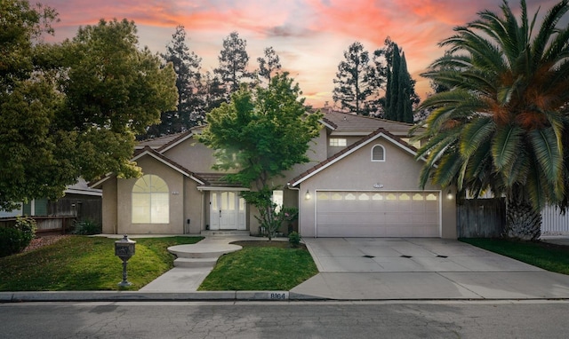 8164 N 8th St, Fresno, CA 93720 - view of front facade with stucco siding, a garage, driveway, and a tiled roof