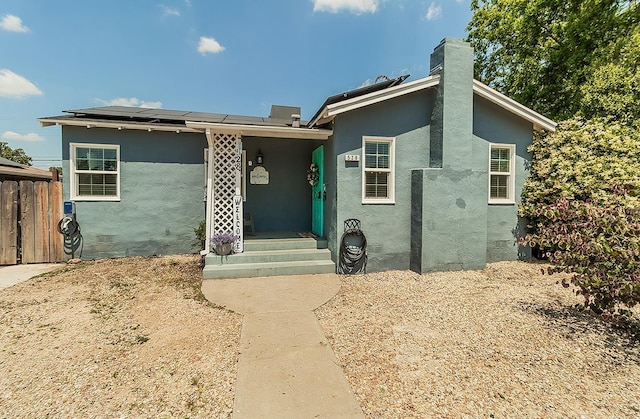 528 W Yale Ave, Fresno, CA 93705 - view of front of property featuring a chimney, stucco siding, and roof mounted solar panels