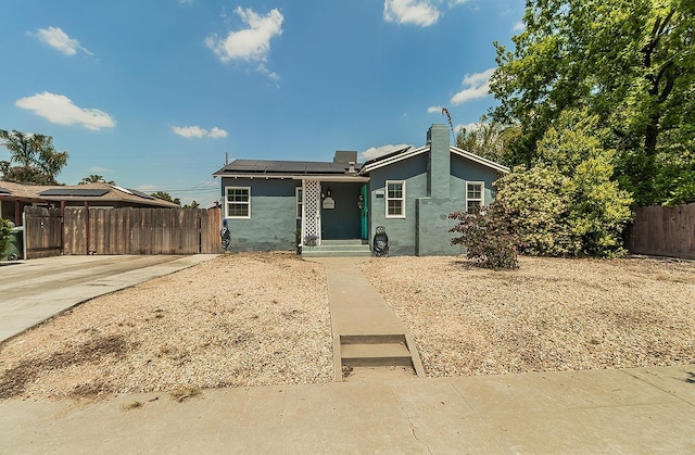 528 W Yale Ave, Fresno, CA 93705 - view of front facade featuring roof mounted solar panels, stucco siding, and fence