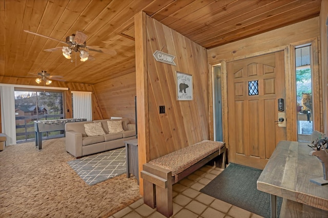 39090 Woodland Rd, Shaver Lake, CA 93664 - entryway with wood ceiling, plenty of natural light, wooden walls, ceiling fan, and carpet floors