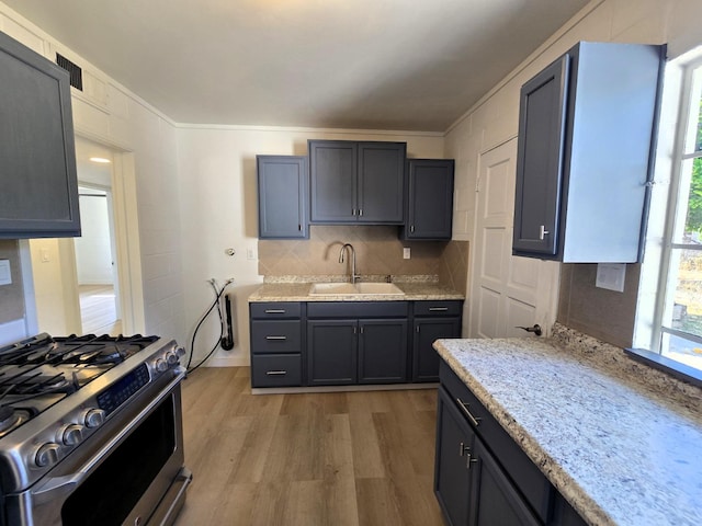 155 E Hampton Way, Fresno, CA 93704 - kitchen featuring light stone countertops, light wood-style flooring, a sink, gas range, and tasteful backsplash