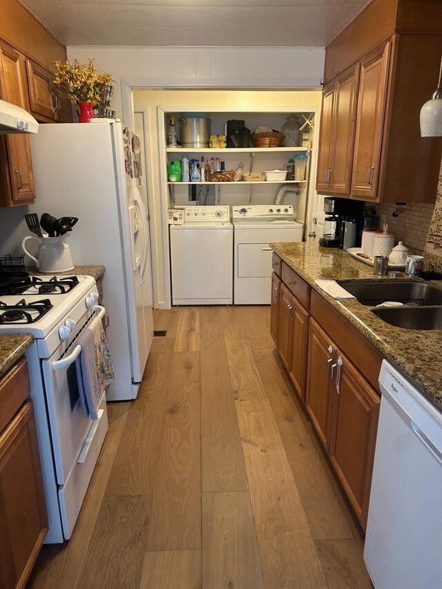 7676 N Fresno St Unit Sp 20, Fresno, CA 93720 - kitchen with white appliances, separate washer and dryer, light wood-style flooring, a sink, and brown cabinets
