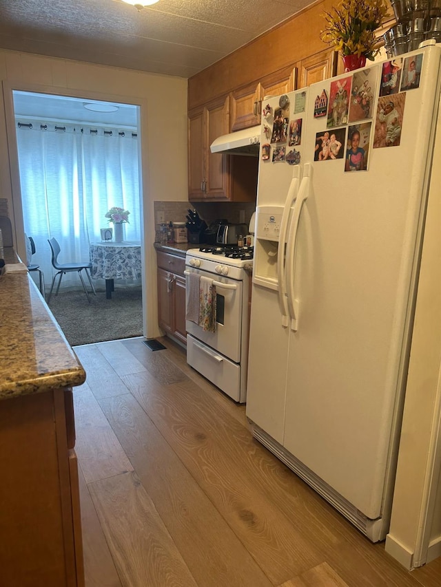 7676 N Fresno St Unit Sp 20, Fresno, CA 93720 - kitchen featuring white appliances, wood finished floors, and under cabinet range hood