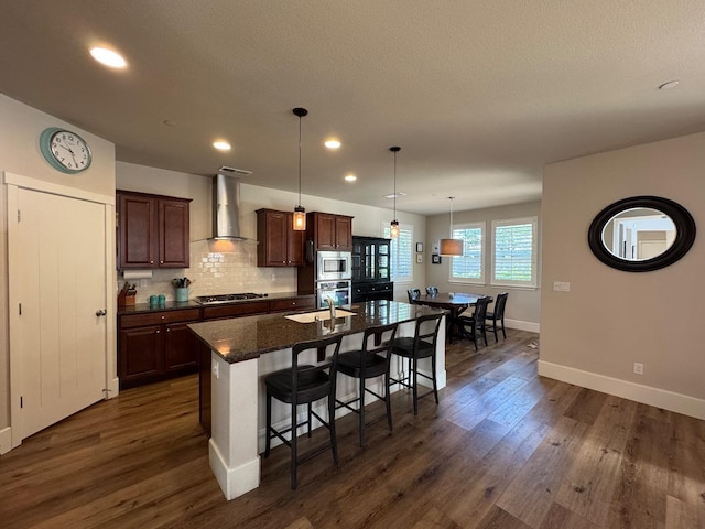 1885 N Whitehorse, Clovis, CA 93619 - kitchen with wall chimney range hood, stainless steel appliances, dark wood-style flooring, and a kitchen bar
