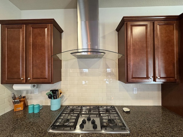 1885 N Whitehorse, Clovis, CA 93619 - kitchen featuring backsplash, dark stone countertops, wall chimney exhaust hood, and stainless steel gas cooktop