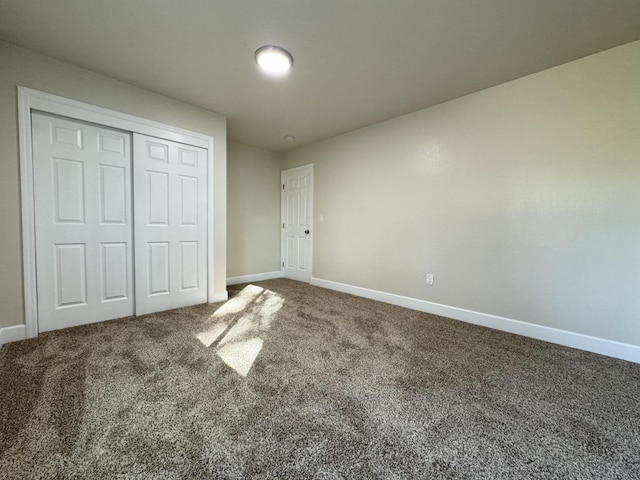 unfurnished bedroom with carpet flooring, a closet, and baseboards