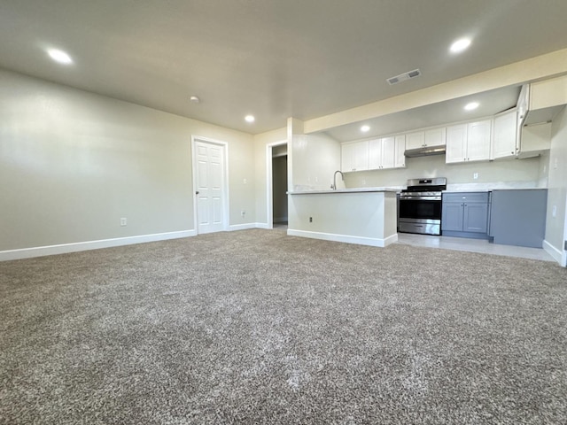 kitchen with stainless steel gas range oven, recessed lighting, under cabinet range hood, visible vents, and open floor plan