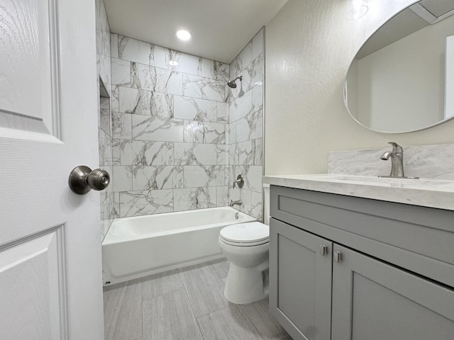 bathroom featuring toilet, bathing tub / shower combination, vanity, and recessed lighting