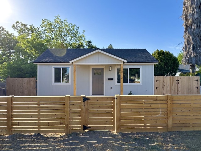 bungalow featuring roof with shingles and a fenced front yard