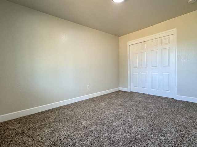 unfurnished bedroom with carpet flooring, baseboards, and a closet