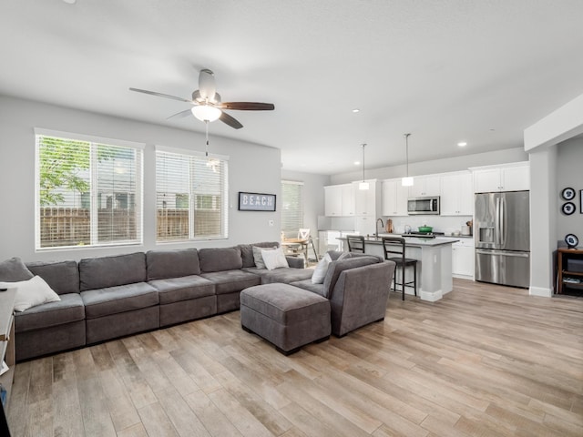 living area with ceiling fan, recessed lighting, a healthy amount of sunlight, and light wood-type flooring