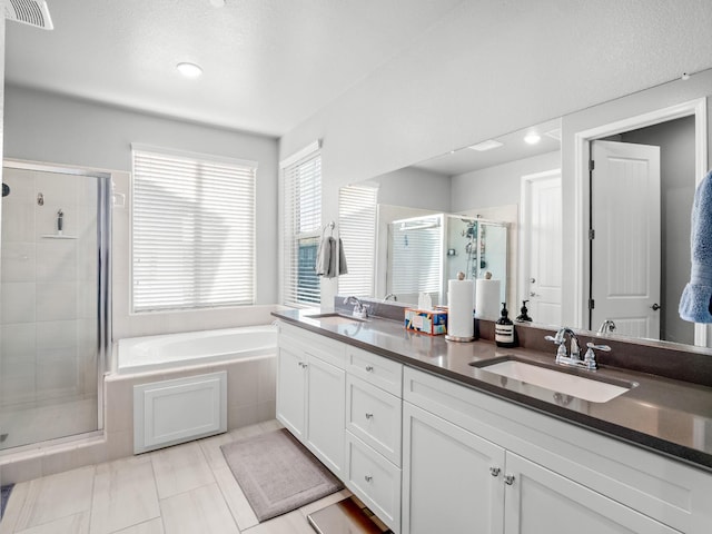 bathroom featuring a garden tub, visible vents, a stall shower, and a sink