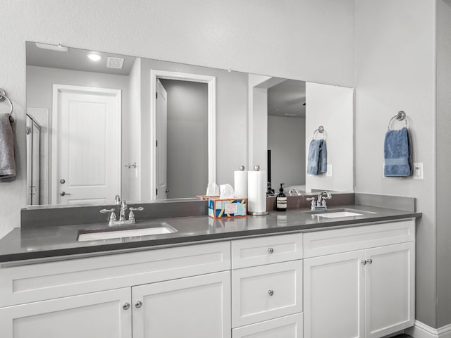 bathroom with a sink, double vanity, toilet, and a shower stall