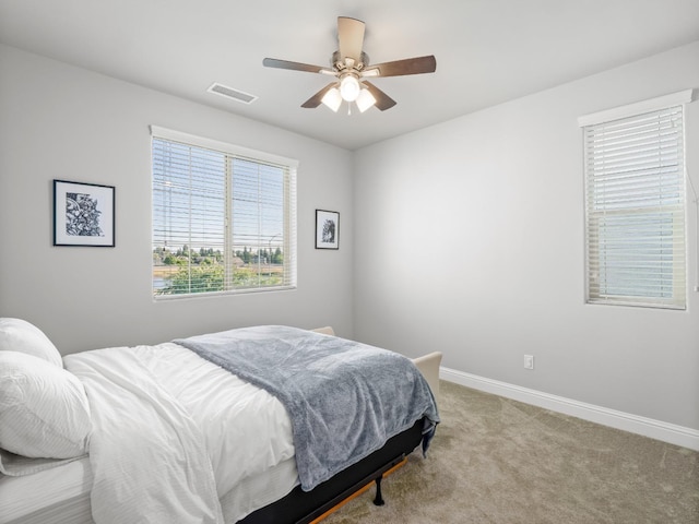 bedroom with baseboards, ceiling fan, visible vents, and carpet floors