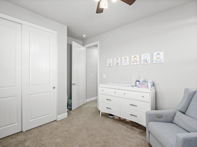 sitting room with ceiling fan, light colored carpet, and baseboards