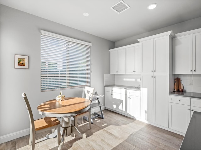 dining space featuring light wood finished floors, baseboards, visible vents, and recessed lighting