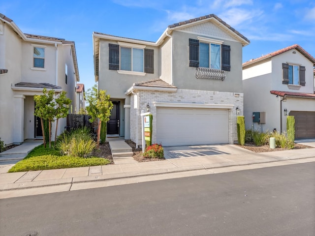 traditional-style home with concrete driveway, a tiled roof, stucco siding, and a garage