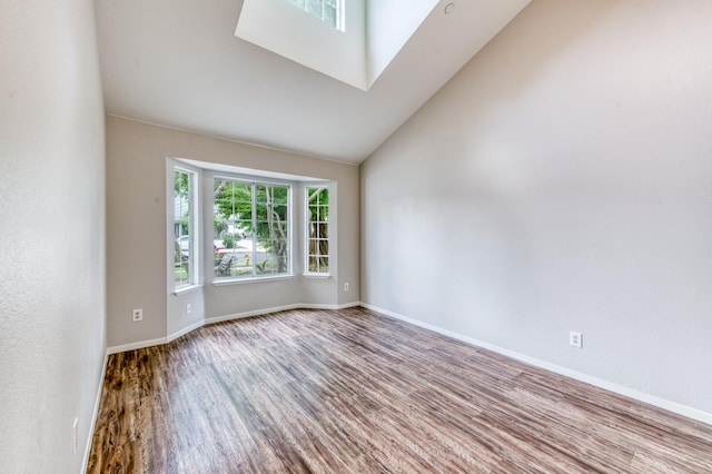 944 N Chapel Hill Ave, Clovis, CA 93611 - spare room featuring a skylight, baseboards, high vaulted ceiling, and wood finished floors
