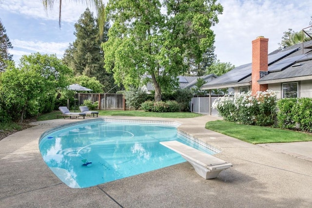 view of swimming pool with a diving board, a lawn, a fenced backyard, a patio area, and a fenced in pool