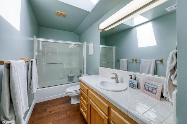 full bath featuring toilet, vanity, visible vents, and wood finished floors