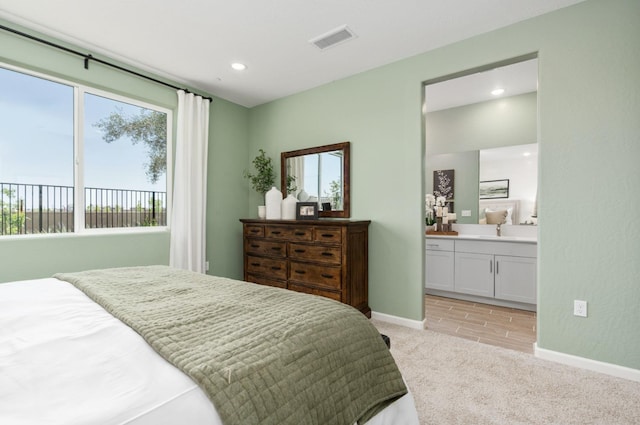 bedroom featuring multiple windows, light carpet, visible vents, and a sink