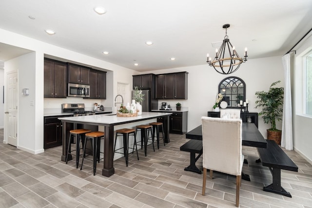 dining space featuring recessed lighting, light wood-type flooring, baseboards, and a notable chandelier