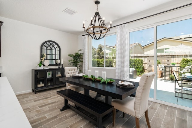 dining area featuring an inviting chandelier, wood finish floors, baseboards, and visible vents