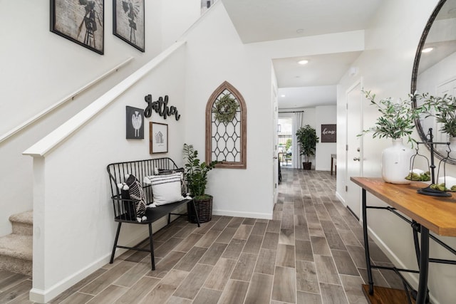 hall featuring baseboards, stairway, recessed lighting, and wood finished floors