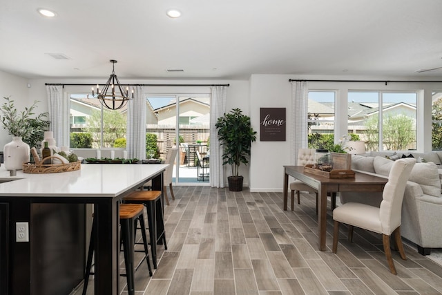 dining space with a chandelier, light wood-style flooring, baseboards, and recessed lighting