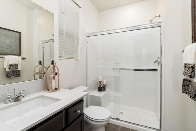 full bathroom with a stall shower, vanity, and toilet