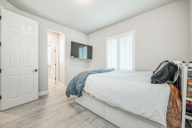 bedroom with light wood-style flooring and baseboards