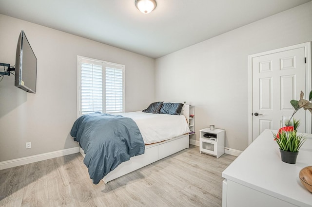 bedroom with light wood-style floors and baseboards