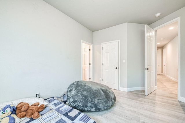bedroom with baseboards, recessed lighting, and light wood-type flooring