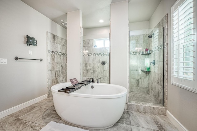 bathroom with a stall shower, baseboards, marble finish floor, and a freestanding tub
