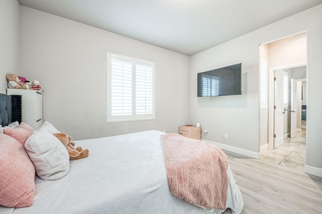 bedroom with light wood-style flooring and baseboards