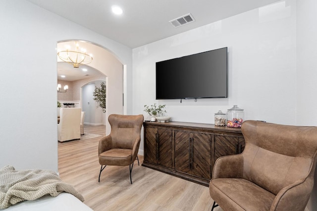 living area featuring recessed lighting, light wood finished floors, an inviting chandelier, visible vents, and arched walkways