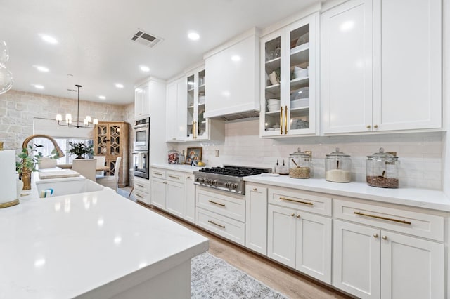 kitchen featuring a sink, white cabinetry, visible vents, light countertops, and appliances with stainless steel finishes