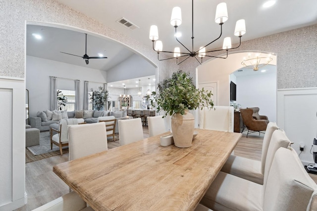 dining room featuring recessed lighting, visible vents, ceiling fan with notable chandelier, wood finished floors, and arched walkways