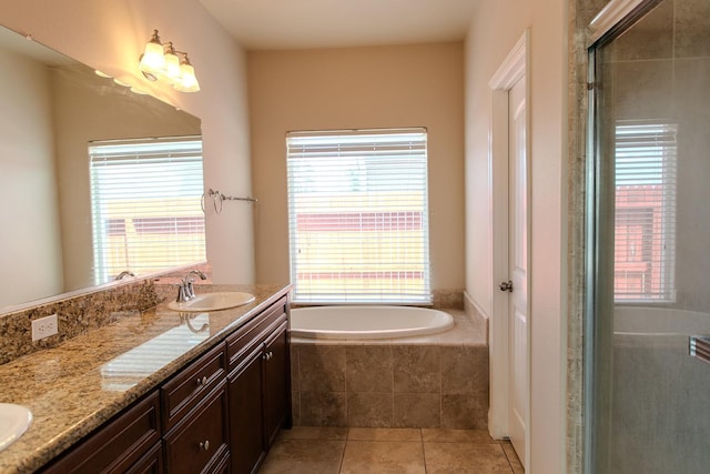 full bath with a bath, a sink, a shower stall, tile patterned floors, and double vanity