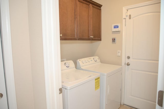 clothes washing area featuring independent washer and dryer and cabinet space