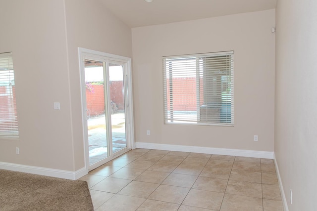 unfurnished room featuring baseboards and light tile patterned flooring