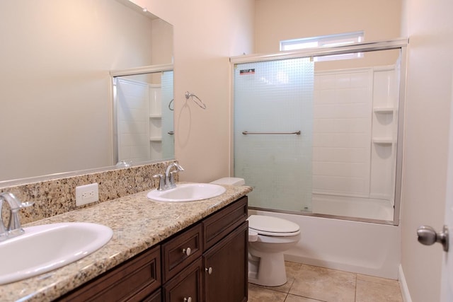 full bathroom featuring toilet, combined bath / shower with glass door, double vanity, and a sink