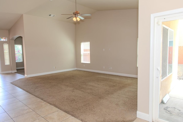 spare room featuring visible vents, ceiling fan, arched walkways, light carpet, and light tile patterned flooring