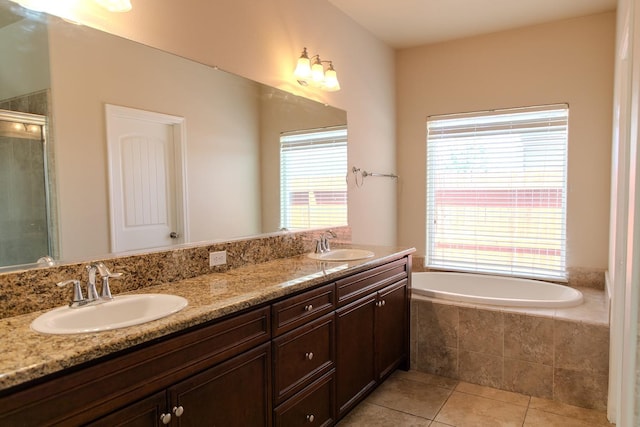 full bathroom featuring a sink, tile patterned flooring, double vanity, and a bath
